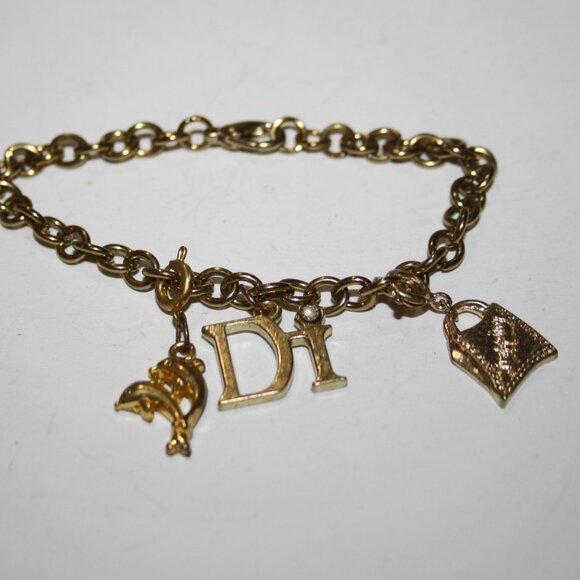 Beautiful gold charm bracelet by Diamond Internation with 3 charms Dolph… - Picture 1 of 3